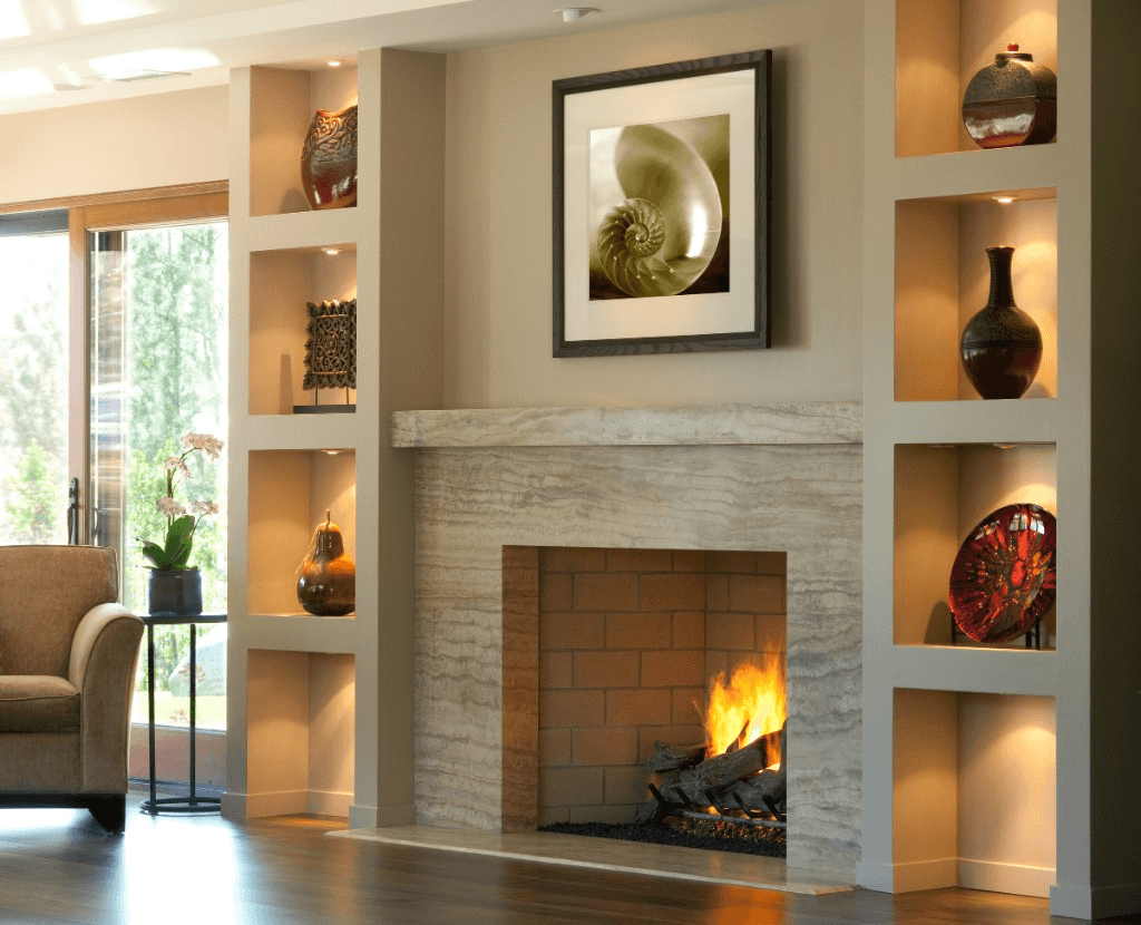 Stone fireplace with thick mantel flanked by lit built-in shelves in a living room accent wall